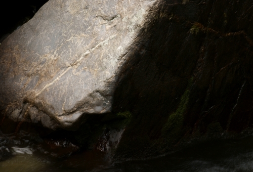 Light and dark - a boulder opposite the falls